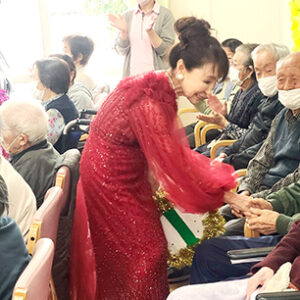 深紅のドレスで握手で応える美空えり子さん